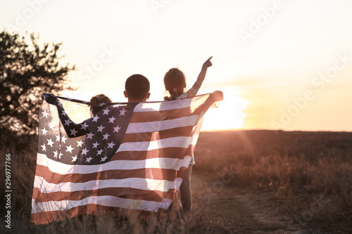 A happy family with an American flag at sunset.