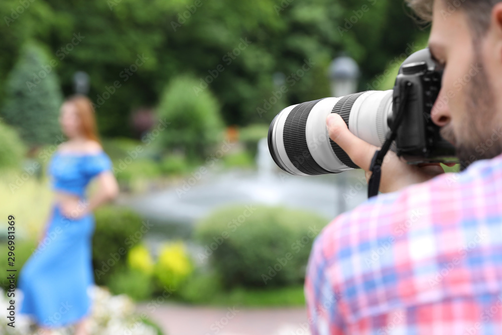 Photographer taking photo of woman with professional camera in park Photographer taking photo of woman with professional camera in park
