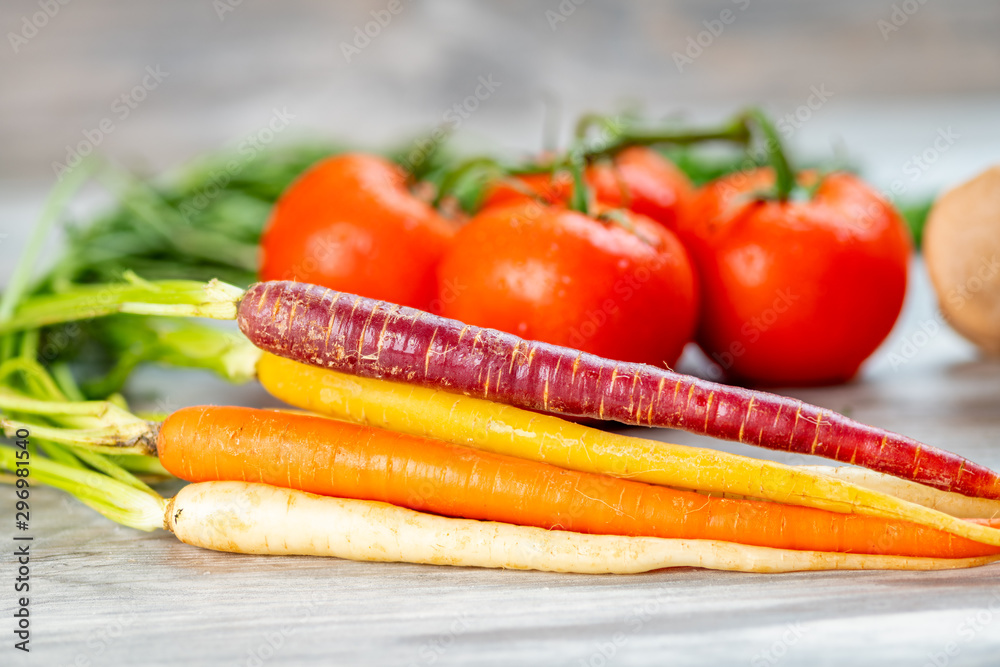 Close up of carrots with tomatoes in the background Close up of carrots with tomatoes in the background