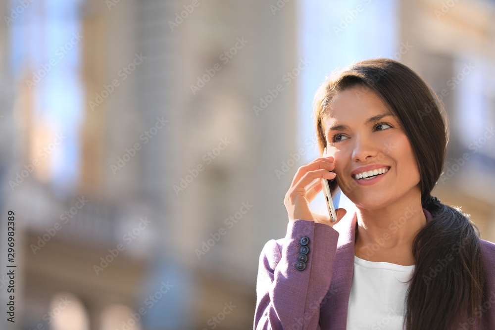 Beautiful businesswoman talking on phone outdoors. Space for text Beautiful businesswoman talking on phone outdoors. Space for text