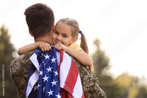 Foto Father in military uniform with American flag and his daughter at sunny park
