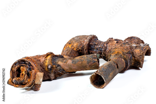 Fragments of old cast-iron water pipes on white background. After many years of operation corroded metal pipe was destroyed. Rusty steel tube with holes of metallic corrosion. Rusty cast iron, metal