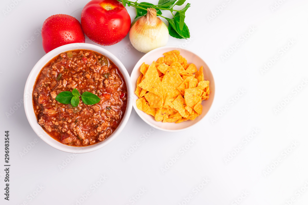 Bolognese (also know as Bolognesa or Bolonhesa) sauce and corn chips nachos in a white bowl isolated in white background, soft light, studio photo, copy space Bolognese (also know as Bolognesa or Bolonhesa) sauce and corn chips nachos in a white bowl isolated in white background, soft light, studio photo, copy space