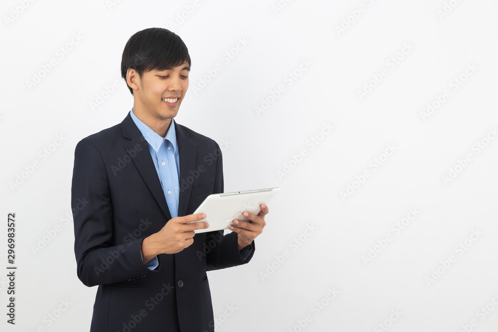 Young handsome asian business man playing and looking to tablet computer with smiling isolated on white background. Young handsome asian business man playing and looking to tablet computer with smiling isolated on white background.