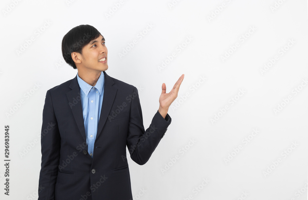 Young asian business man pointing to the side with a hand to present a product or an idea while looking forward isolated on white background. Young asian business man pointing to the side with a hand to present a product or an idea while looking forward isolated on white background.
