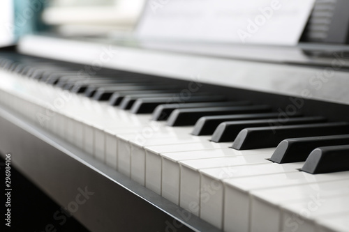 Modern piano with music sheets in room, closeup