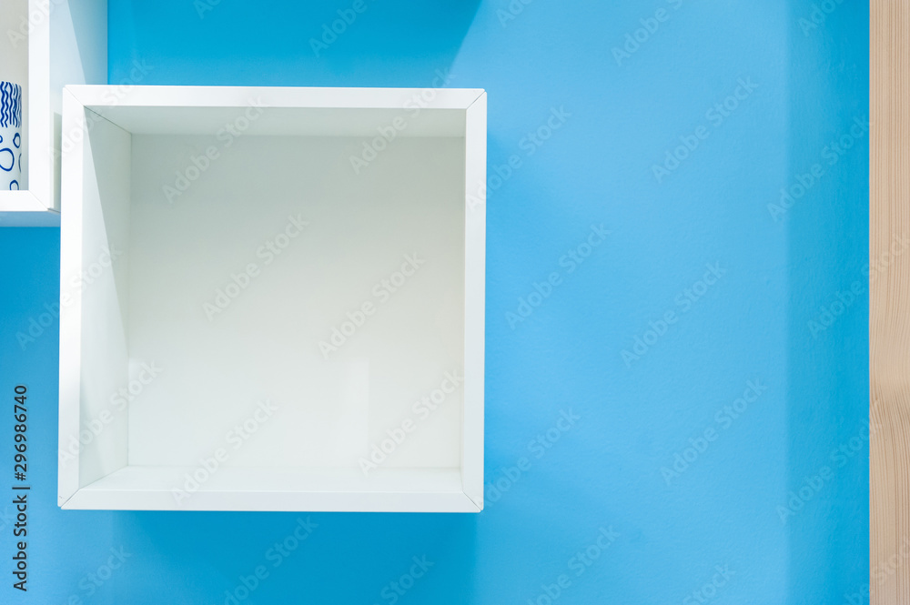 White box shelf isolated on blue background..Empty white shop shelf, retail shelf on blue vintage background. White box shelf isolated on blue background..Empty white shop shelf, retail shelf on blue vintage background.