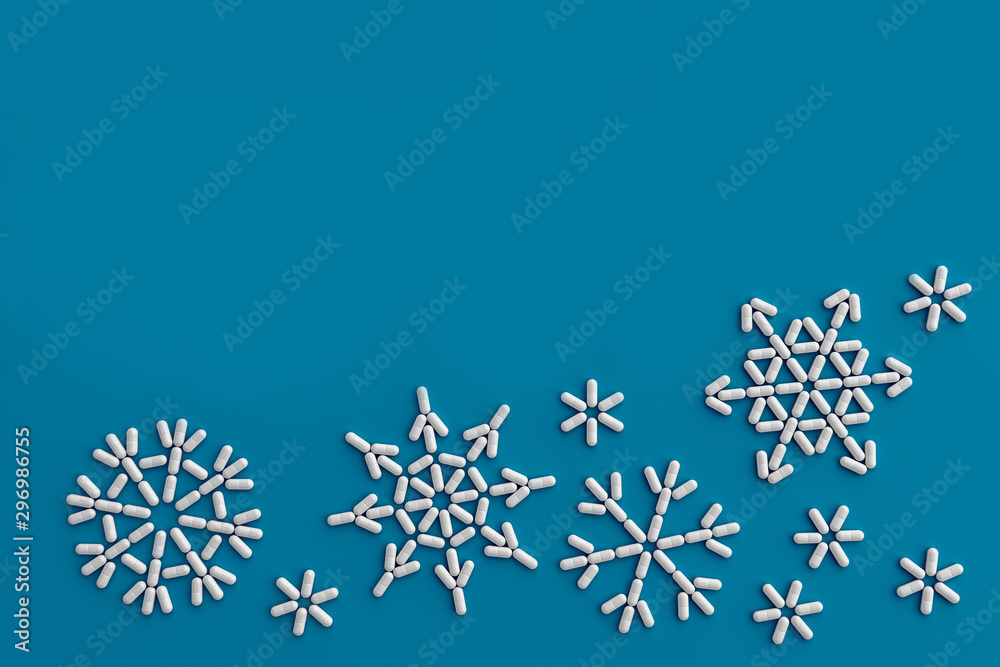 Fototapeta premium A lot of pills scattered on a blue background in the form of snowflakes . 3D illustration
