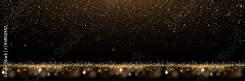 Gold glitter and shiny golden rain on black background. Vector horizontal luxury background. photo