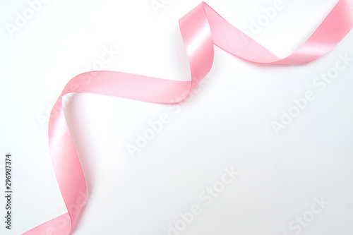 Fototapeta Curled pink ribbon with highlights isolated on white background, top view