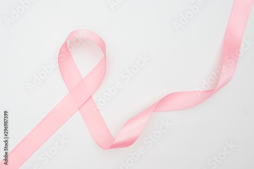 Curled pink ribbon with highlights isolated on white background, top view