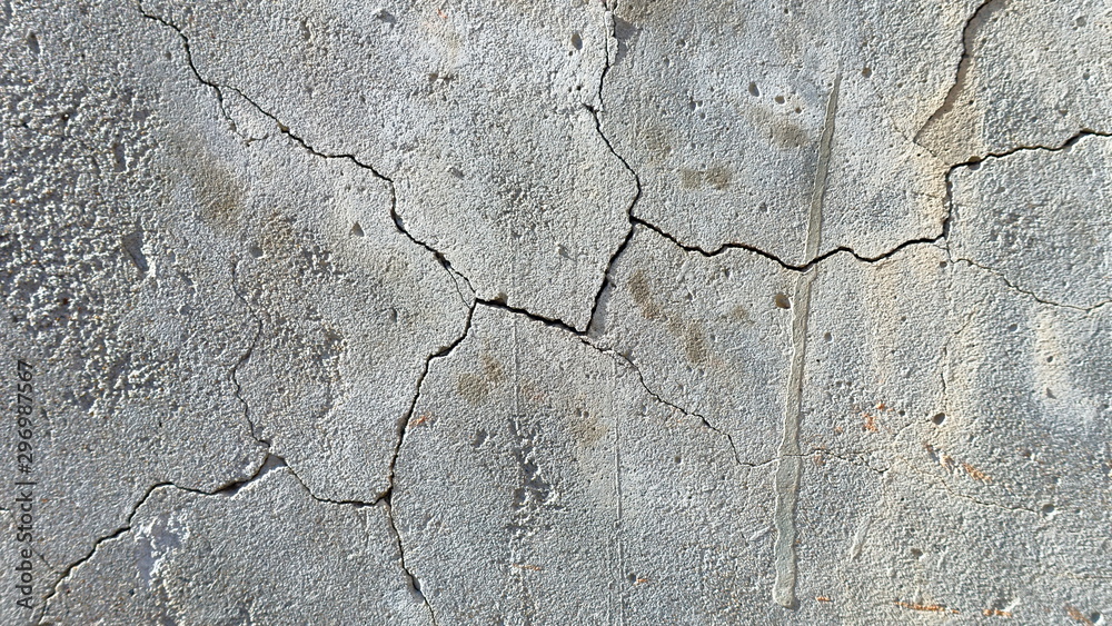 Fototapeta premium A crack on the concrete wall surface of a house in Los Angeles. Background image for design