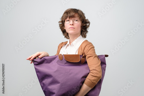 Foto Young funny greedy woman carrying big shopping bag