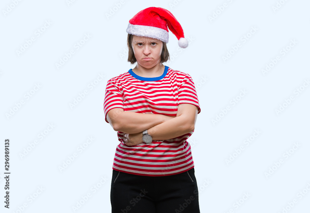 Young adult woman with down syndrome wearing christmas hat over isolated background skeptic and nervous, disapproving expression on face with crossed arms. Negative person. Young adult woman with down syndrome wearing christmas hat over isolated background skeptic and nervous, disapproving expression on face with crossed arms. Negative person.