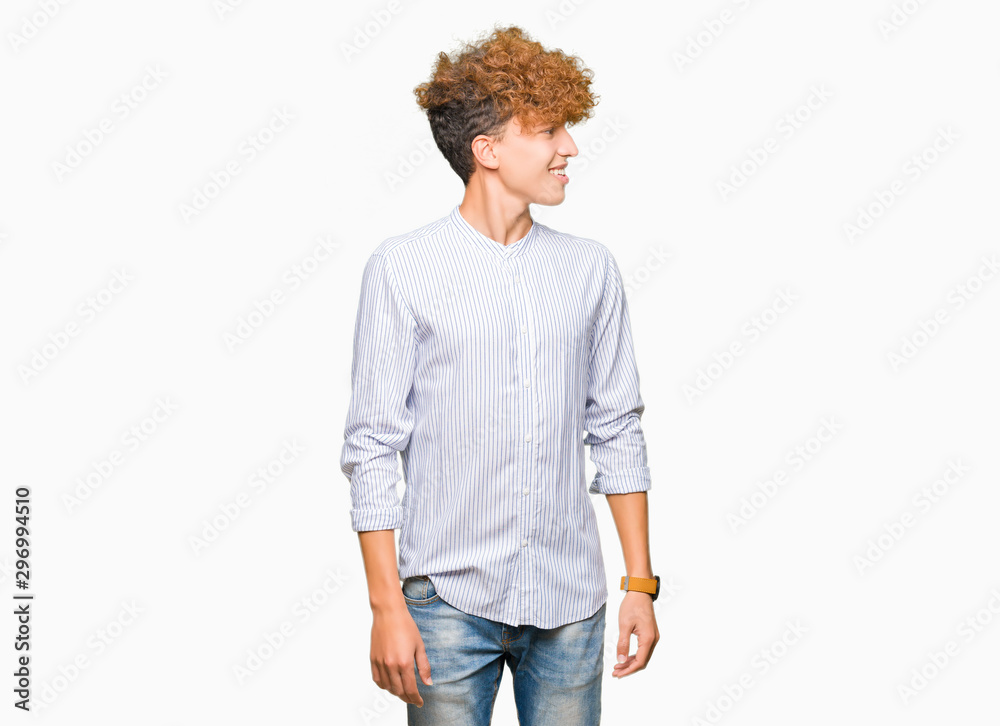 Young handsome business man with afro hair wearing elegant shirt looking away to side with smile on face, natural expression. Laughing confident. Young handsome business man with afro hair wearing elegant shirt looking away to side with smile on face, natural expression. Laughing confident.