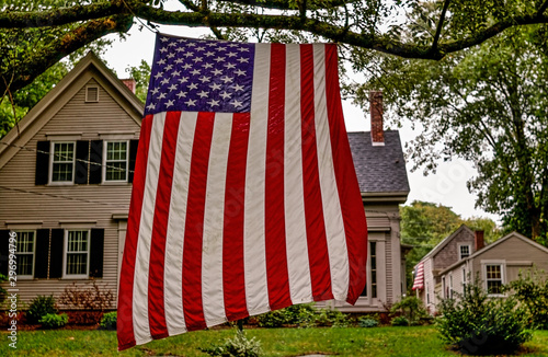 Brewster, Massachucetts, USA - September 3, 2006- An American flag hangs vertically in a tree outside a typical Cape Cod house beside Highway MA-6A on Labor Day.jpg photo