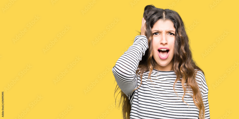 Young beautiful woman wearing stripes sweater Smiling confident touching hair with hand up gesture, posing attractive Young beautiful woman wearing stripes sweater Smiling confident touching hair with hand up gesture, posing attractive