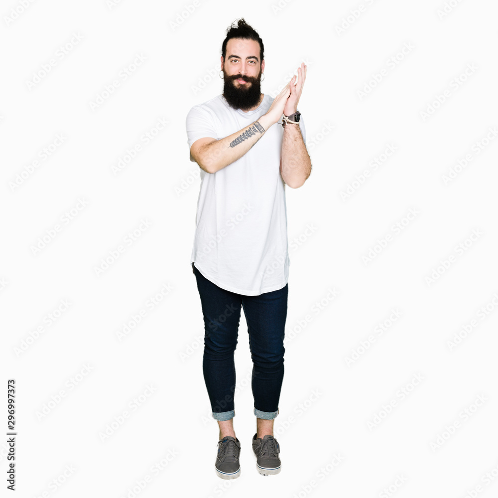 Young hipster man with long hair and beard wearing casual white t-shirt Clapping and applauding happy and joyful, smiling proud hands together