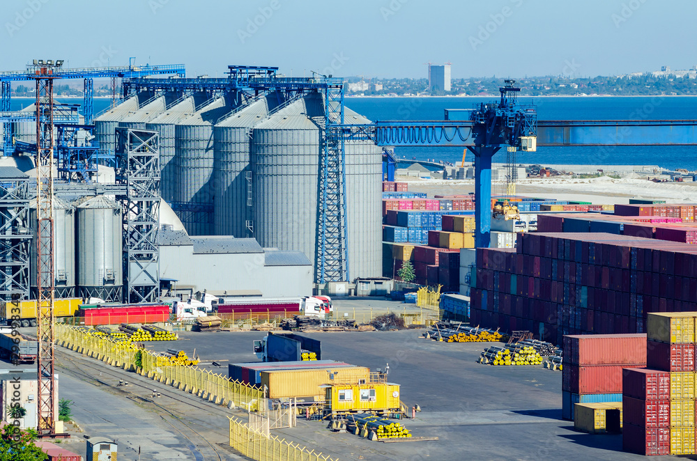 Granary with containers for storage and loading of grain in the seaport. Grain transportation, agribusiness - obrazy, fototapety, plakaty 