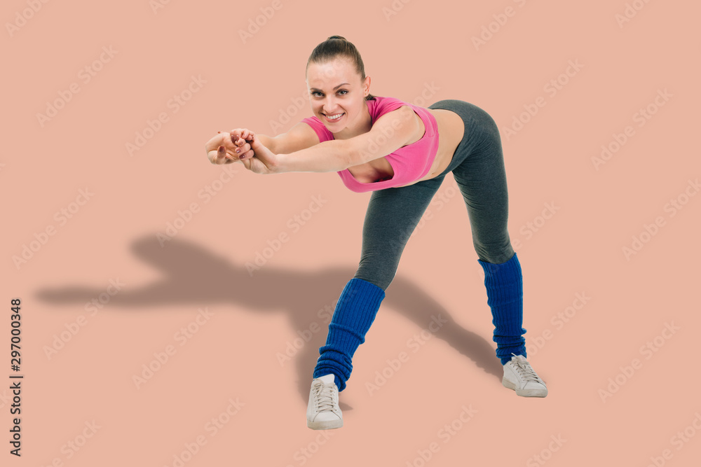 Smiling young athletic woman doing slope on color background