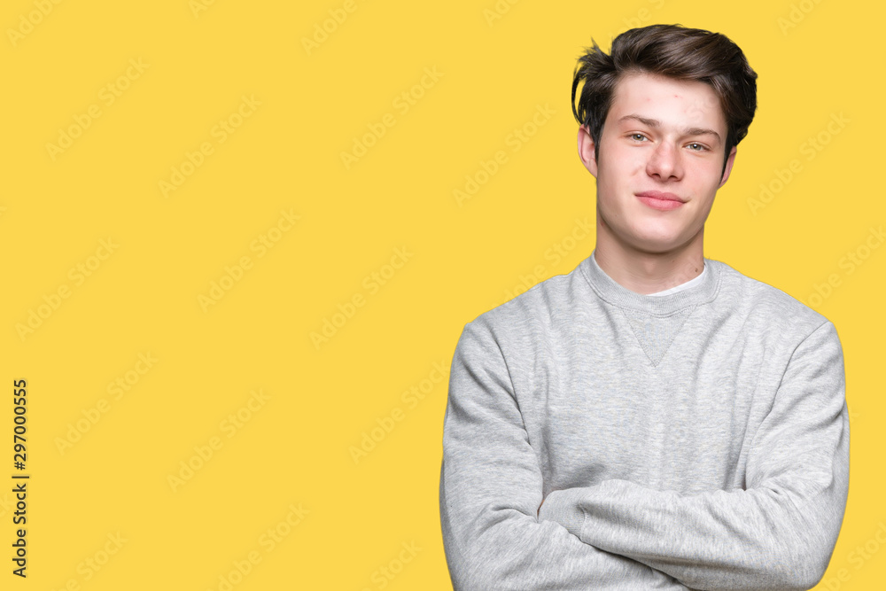 Young handsome sporty man wearing sweatshirt over isolated background happy face smiling with crossed arms looking at the camera. Positive person.