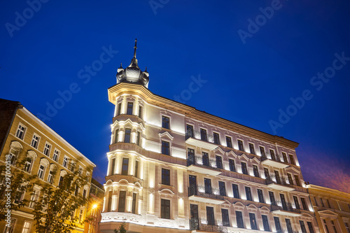 A rebuilt historic, Art Nouveau tenement house at night in Poznan.