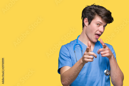 Young doctor wearing medical uniform over isolated background pointing fingers to camera with happy and funny face. Good energy and vibes.