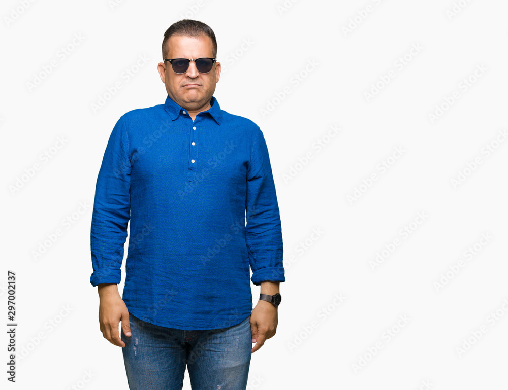 Middle age arab man wearing sunglasses over isolated background with serious expression on face. Simple and natural looking at the camera. Middle age arab man wearing sunglasses over isolated background with serious expression on face. Simple and natural looking at the camera.