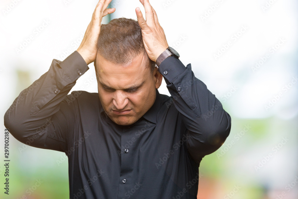 Handsome middle age arab business man over isolated background suffering from headache desperate and stressed because pain and migraine. Hands on head.