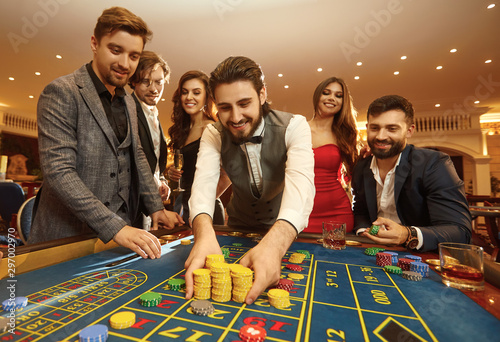 Fototapeta Happy guy playing gambling at a casino roulette
