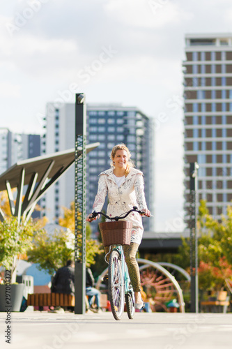 Young happy woman riding a bicycle in the city