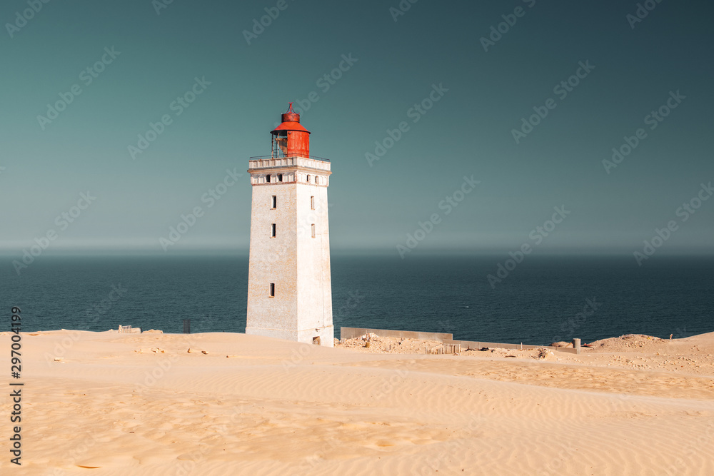 White beach sand dunes at the north danish coastline in summer sun light and blue sky. Rubjerg Knude Lighthouse, Lønstrup in North Jutland in Denmark, Skagerrak, North Sea