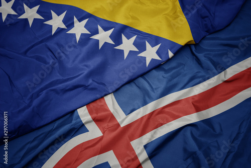 waving colorful flag of iceland and national flag of bosnia and herzegovina.