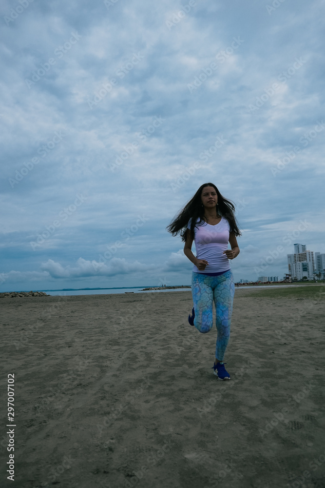 Girl running on the beach in the morning. Fitness concept