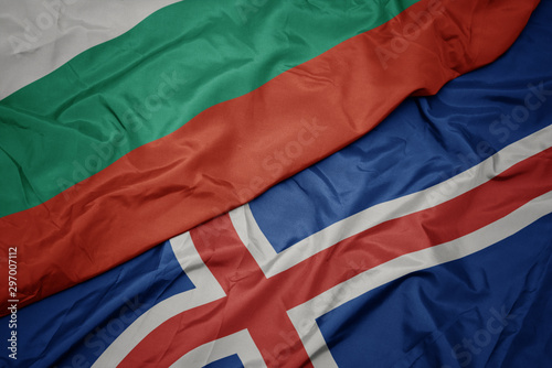 waving colorful flag of iceland and national flag of bulgaria.