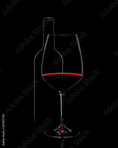 Silhouette of red wine glass with bottle on black background