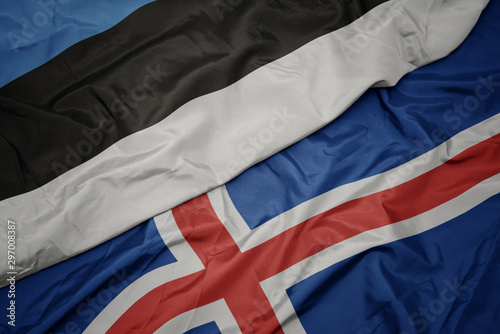 waving colorful flag of iceland and national flag of estonia.