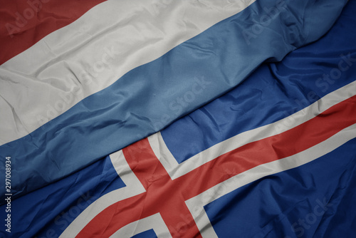 waving colorful flag of iceland and national flag of luxembourg.