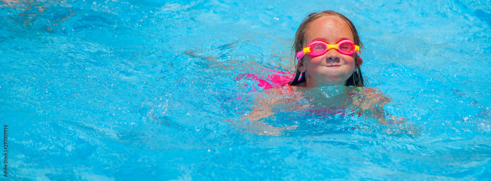 Naklejka premium Happy cute little girl learn to swimming and relaxing in the pool. Holidays in hot countries concept.