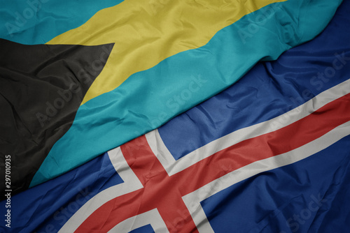 waving colorful flag of iceland and national flag of bahamas.