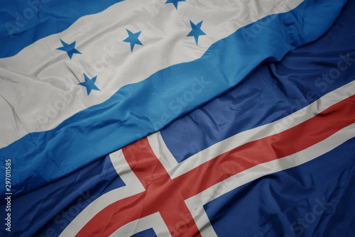 waving colorful flag of iceland and national flag of honduras.