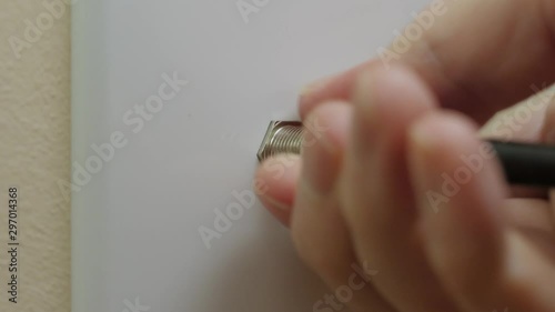 Male electrician connecting coax cable cord to wall outlet. Coaxial wire connection for TV and high speed broadband internet. Television service installation.