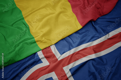waving colorful flag of iceland and national flag of mali.