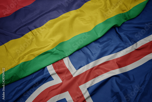 waving colorful flag of iceland and national flag of mauritius.