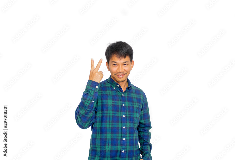 An Asian untidy man in blue plaid shirt is pointing two fingers to the overhead blank space in studio with his hand. An Asian untidy man in blue plaid shirt is pointing two fingers to the overhead blank space in studio with his hand.
