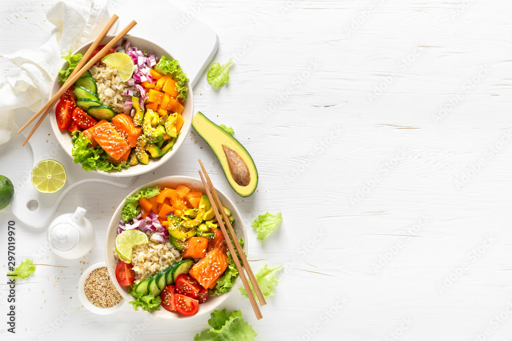 Buddha bowl with grilled salmon fish, fresh cucumber, tomato, onion, sweet pepper, avocado, lettuce salad and rice, healthy balanced eating