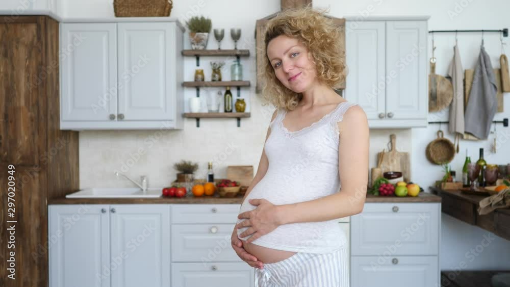 Pregnant Happy Woman Touching Her Belly, Looking At Camera And Smiling. Pregnant Happy Woman Touching Her Belly, Looking At Camera And Smiling.
