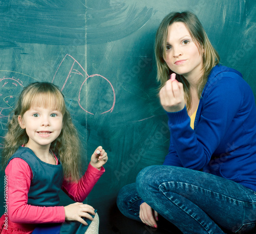 teacher with little girl at blackboard, lifestyle people concept