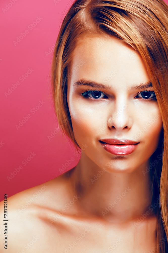 Fototapeta premium young pretty blonde real woman with hairstyle close up and makeup on pink background smiling, stylish fashion look like baby doll