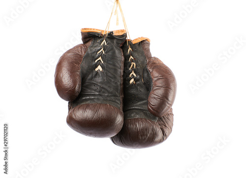 pair of very old vintage brown leather boxing gloves hanging © nndanko